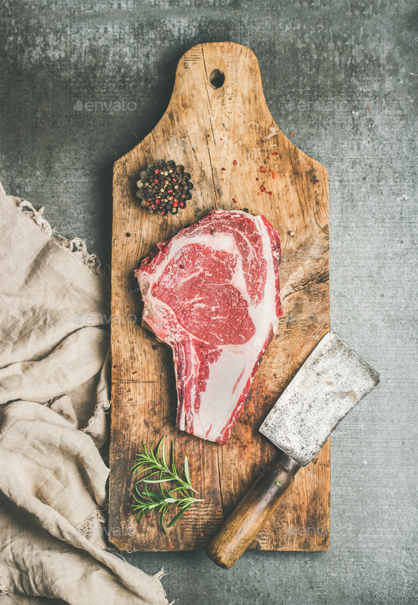 Meat dinner concept with raw beef steak rib-eye with seasoning - Stock Photo - Images