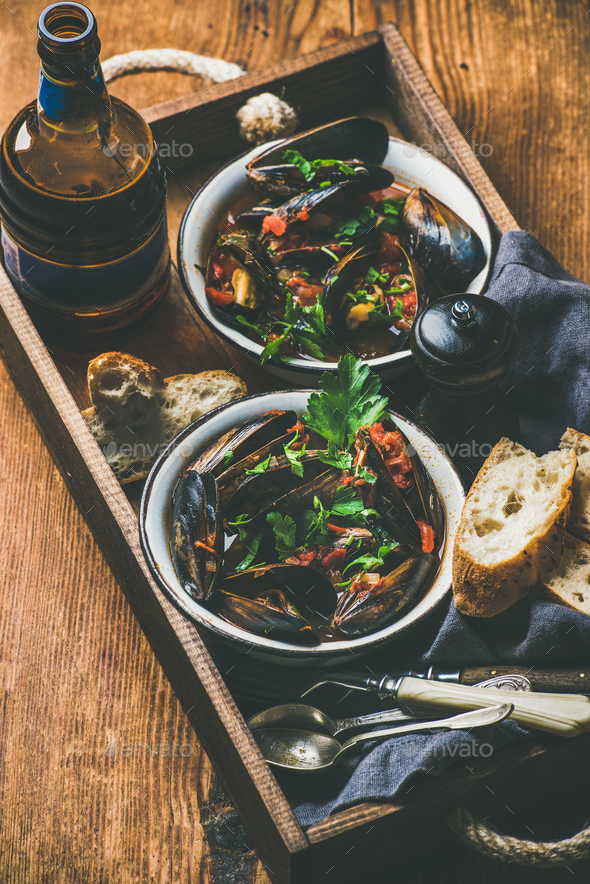 Belgian boiled mussels in tomato sauce and beer in bottle - Stock Photo - Images