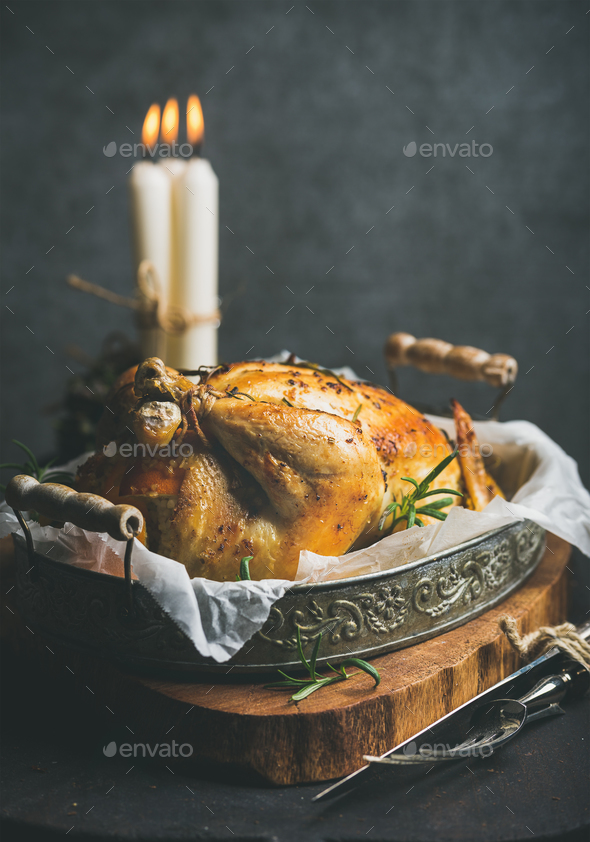 Christmas holiday table set with roasted whole chicken and candles - Stock Photo - Images