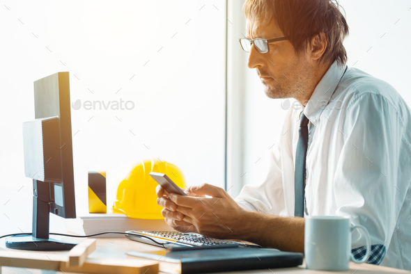 Architect and construction engineer working in office - Stock Photo - Images
