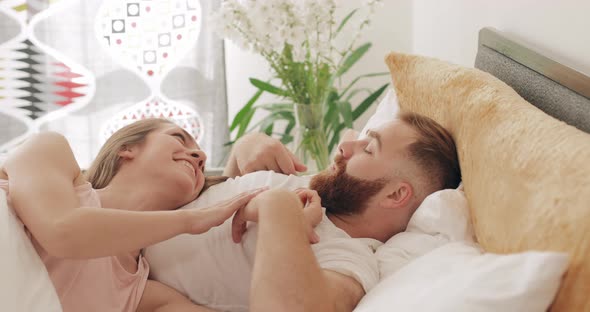 Good Looking Man and Woman Communicating and Smiling While Lying on Bed, Loving Young Couple Talking alt