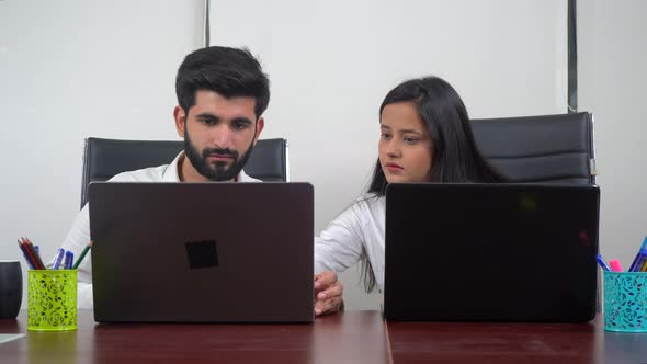 Indian girl helping her colleague in some office work alt