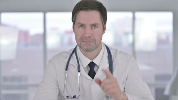 Portrait of Middle Aged Doctor Doing Call Me Sign with Hand alt
