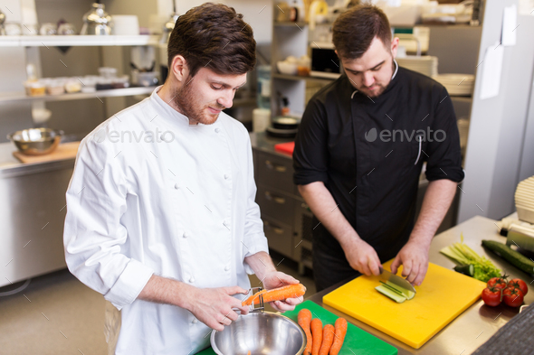 chef and cook cooking food at restaurant kitchen - Stock Photo - Images