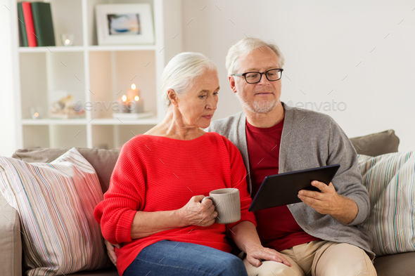 happy senior couple with tablet pc at christmas