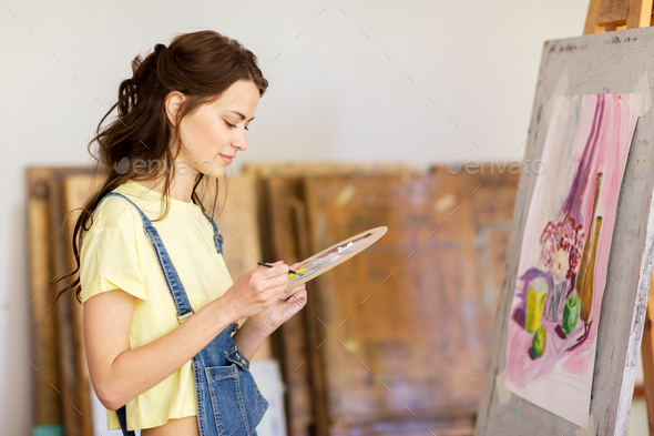 student girl with easel painting at art school - Stock Photo - Images