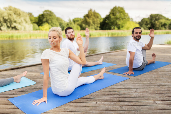 people making yoga in half lord of the fishes pose - Stock Photo - Images