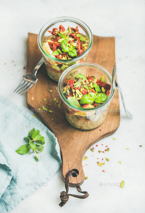 Healthy salad with quionoa, avocado, dried tomatoes on wooden board - Stock Photo - Images