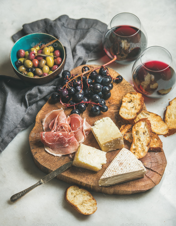 Wine and snack set on wooden board over grey background - Stock Photo - Images