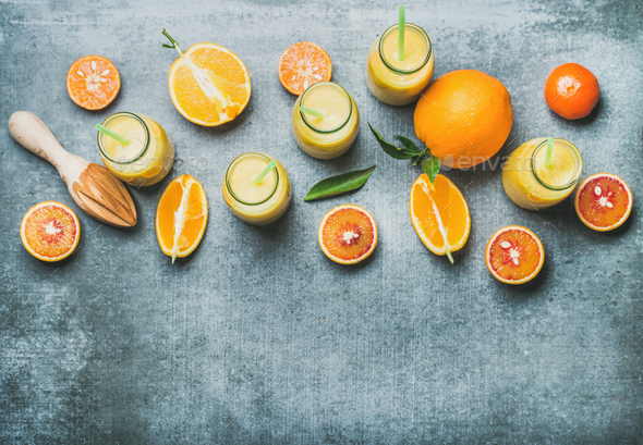 Healthy yellow smoothie in bottles over concrete background, top view - Stock Photo - Images