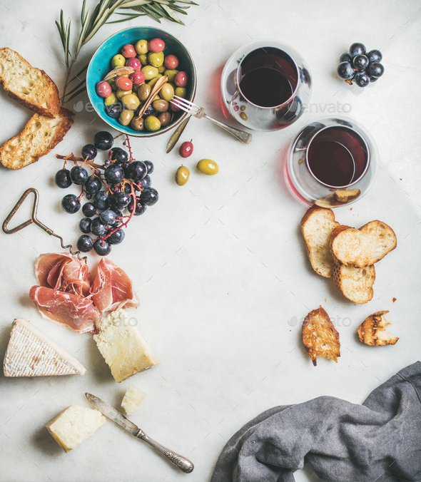 Cheese, olives, grapes, prosciutto, baguette and red wine, top view - Stock Photo - Images