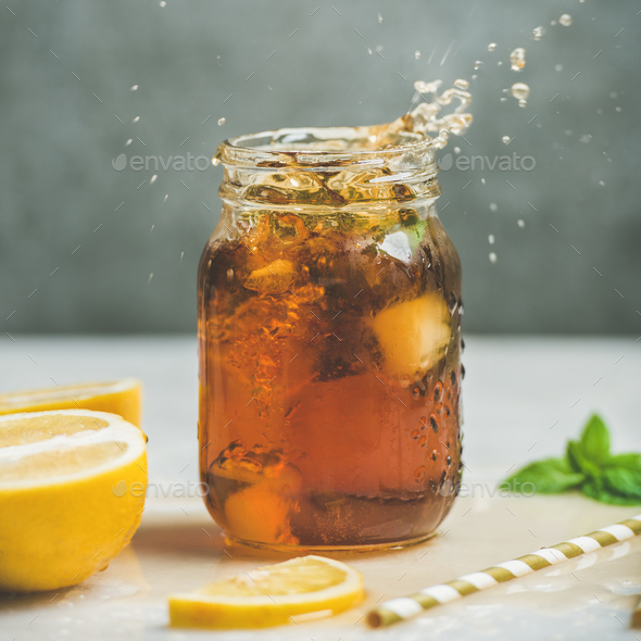 Iced tea with fresh herbs in jar with splashes - Stock Photo - Images
