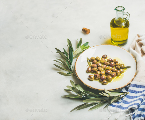 Pickled green Mediterranean olives, olive tree branch and virgin oil - Stock Photo - Images