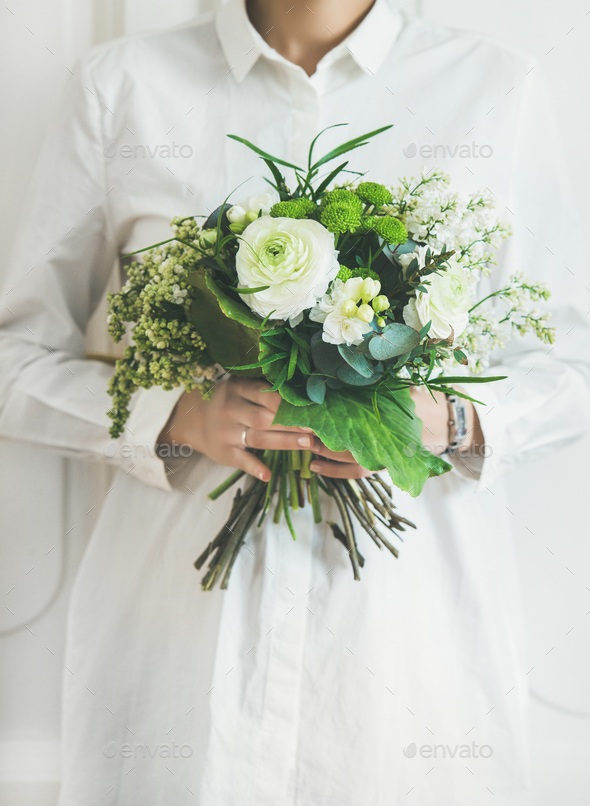 Young woman wearing white clothes holding bouquet. Flower shop concept - Stock Photo - Images