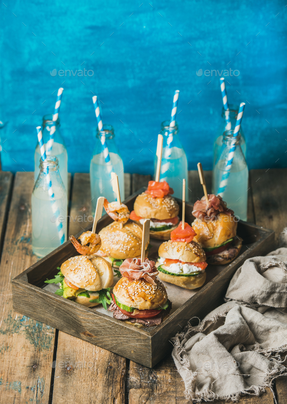 Homemade burgers in wooden tray and lemonade in bottles - Stock Photo - Images