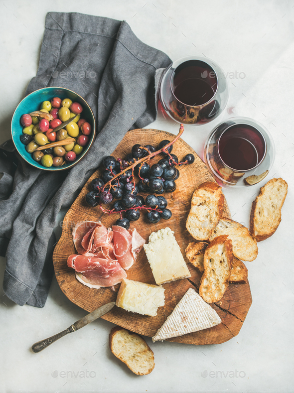 Red wine and snack set on board over grey background - Stock Photo - Images
