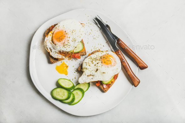 Breakfast toast with fried eggs and vegetables, top view - Stock Photo - Images