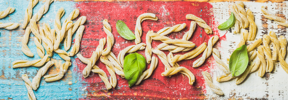 Homemade uncooked pasta casarecce with flour and green basil leaves - Stock Photo - Images
