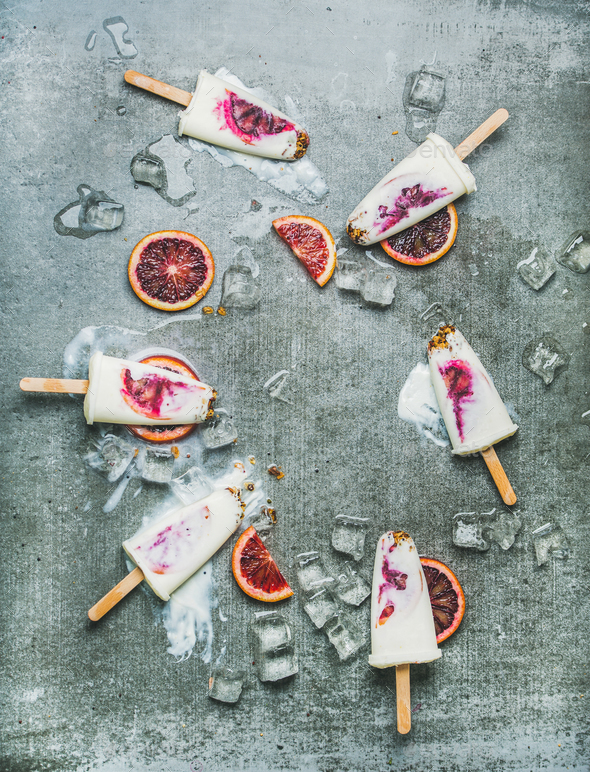 Orange, yogurt, granola popsicles on ice cubes, vertical composition - Stock Photo - Images