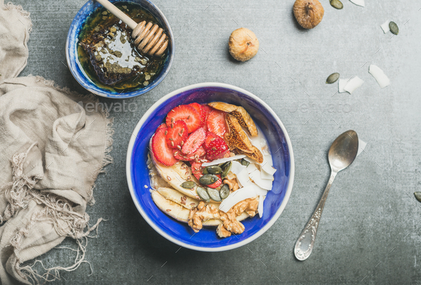 Yogurt, granola, seeds, berry and honey in blue ceramic bowl - Stock Photo - Images