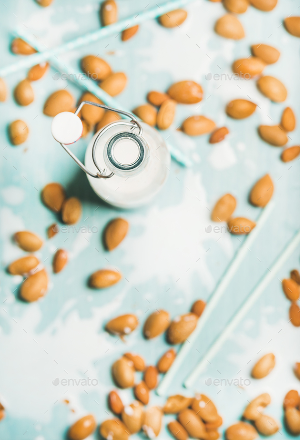 Dairy alternative almond milk in bottle over light blue background - Stock Photo - Images