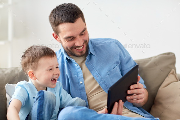 father and son with tablet pc playing at home
