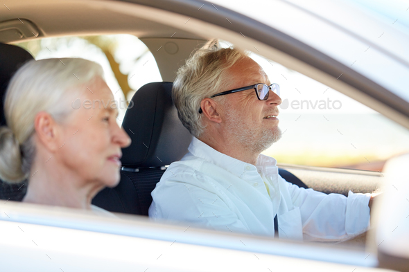 happy senior couple driving in car