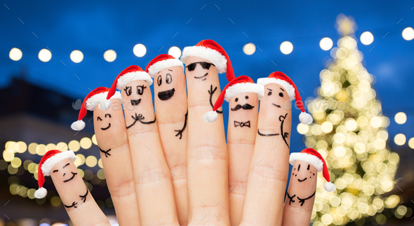 fingers in santa hats over night lights background