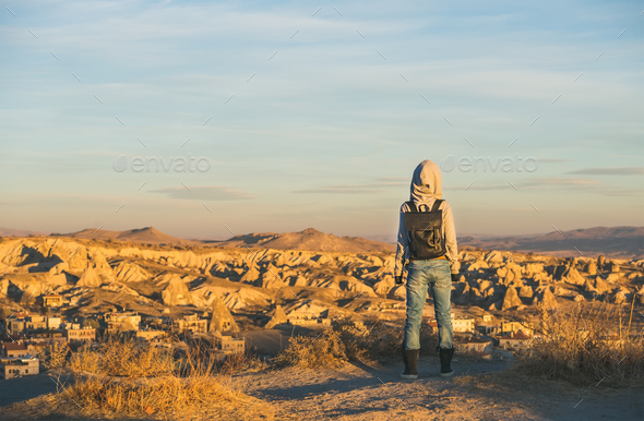 Young woman traveller in hoodie watching sunrise, Cappadocia, Central Turkey - Stock Photo - Images