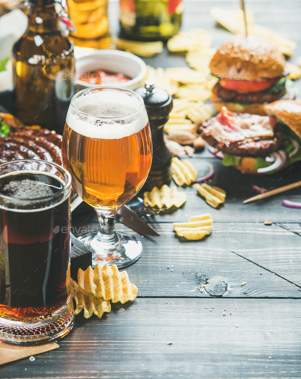 Beer and snack variety on dark wooden scorched background - Stock Photo - Images