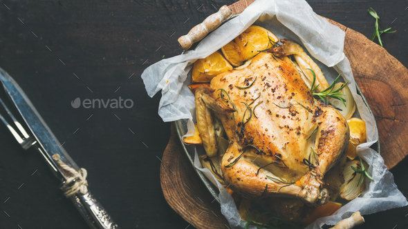 Roasted chicken with oganges, bulgur, rosemary over dark background - Stock Photo - Images