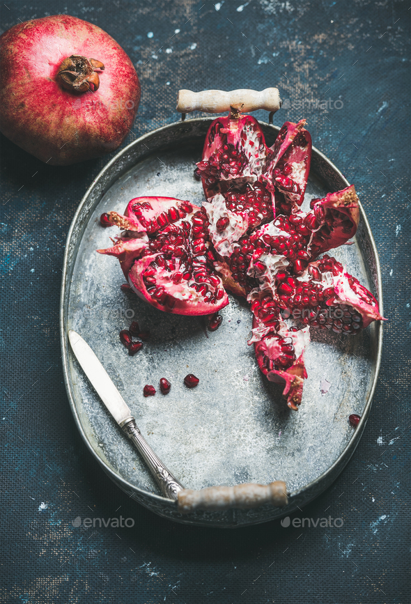 Fresh ripe pomegranate in metal tray over dark plywood background - Stock Photo - Images