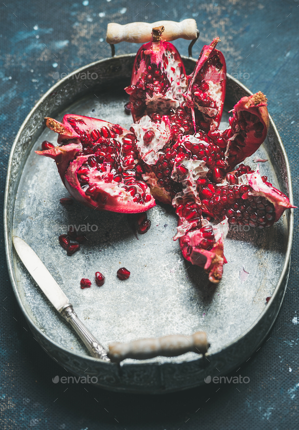 Fresh ripe pomegranate broken in pieces in metal tray - Stock Photo - Images