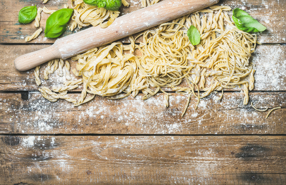 Various homemade fresh uncooked Italian pasta on wooden background - Stock Photo - Images