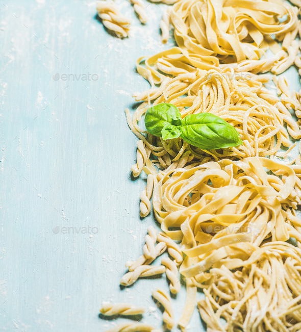 Different kinds of homemade fresh Italian pasta with basil leaves - Stock Photo - Images