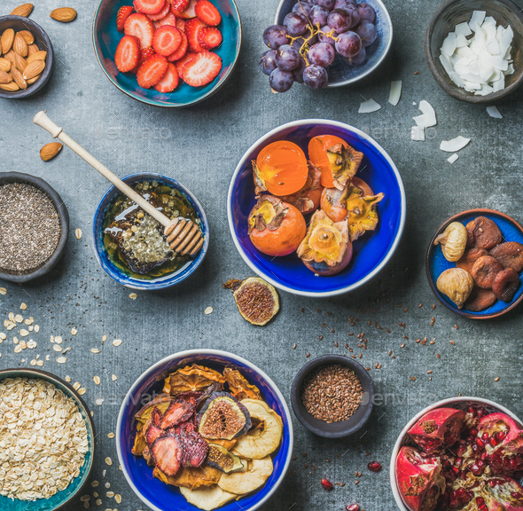 Ingredients for healthy breakfast in bowls over grey stone background - Stock Photo - Images