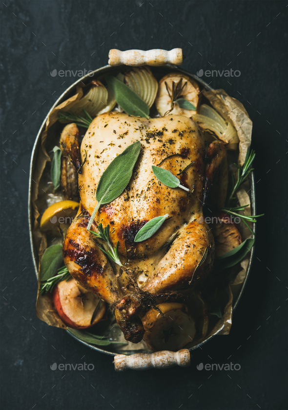 Oven roasted whole chicken with fresh sage leaves and apples - Stock Photo - Images