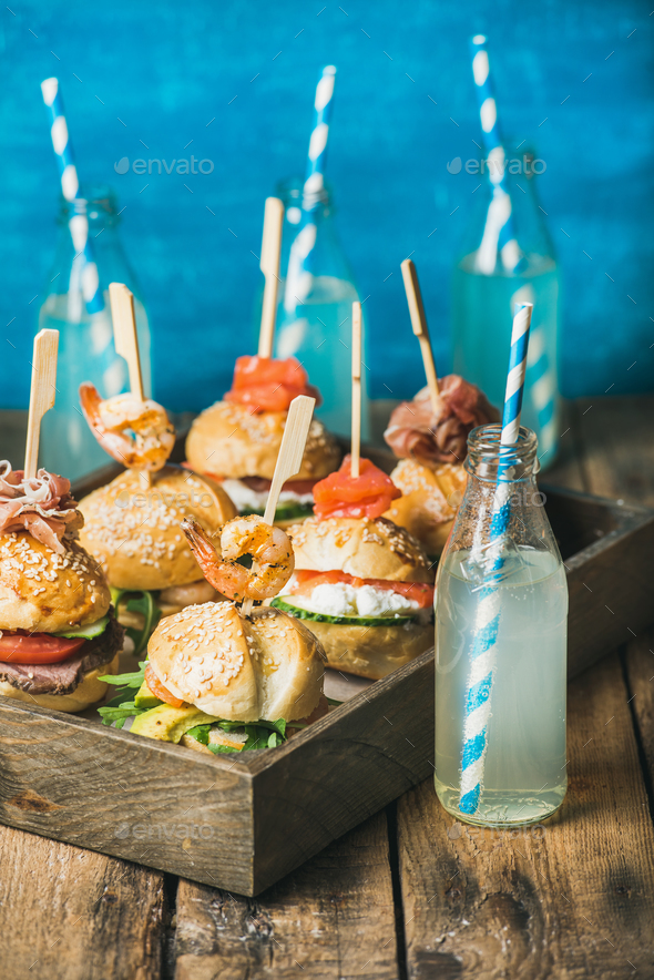 Different homemade burgers with sticks in wooden tray and lemonade - Stock Photo - Images