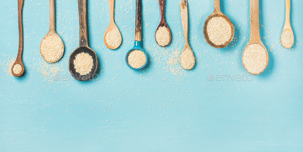 Quinoa seeds in different spoons over light blue background - Stock Photo - Images