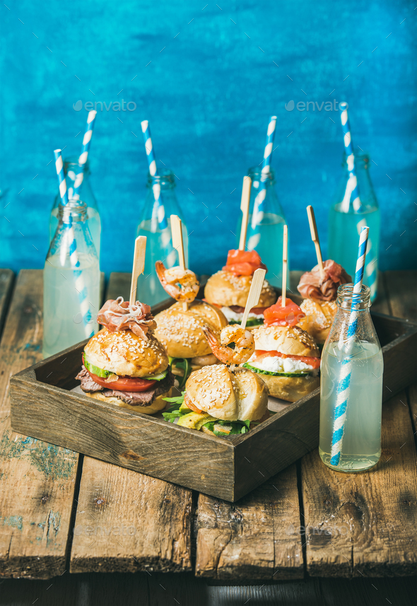 Different burgers with sticks in wooden tray and fresh lemonade - Stock Photo - Images