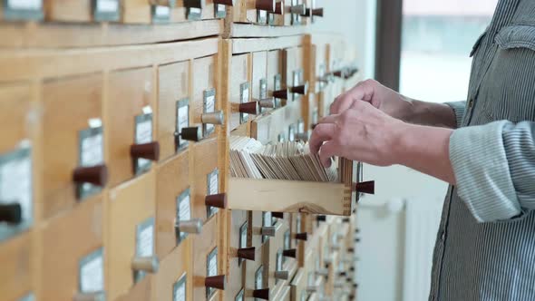 Senior Man is Looking for Information in a File Cabinet alt