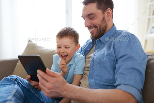 father and son with tablet pc playing at home