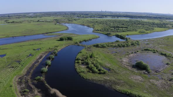 Scenic Aerial View of a River and Green Fields in a Countryside