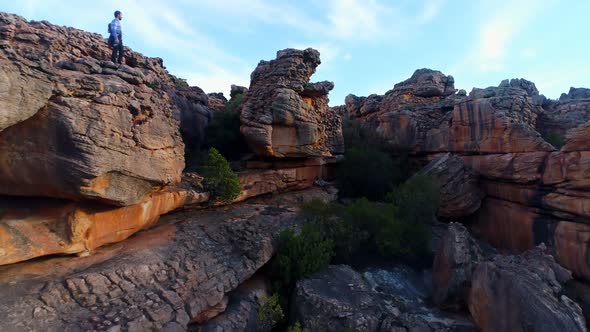 Male rock climber standing over a rocky mountain  alt
