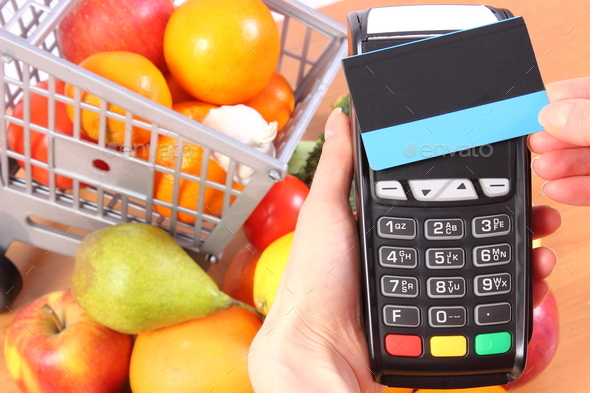 Payment terminal with contactless credit card and fruits and vegetables