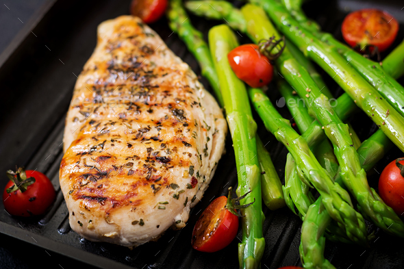 Chicken fillet cooked on a grill and garnish of asparagus