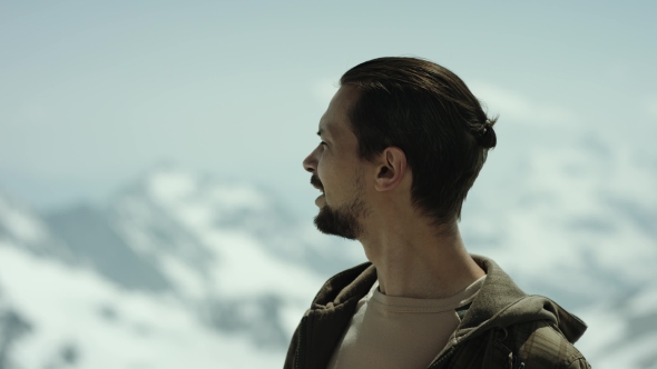 Young Bearded Man at Mountain Top with Scenic View Breath Deep and Looks Around