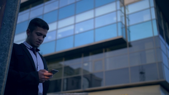 Young Handsome Businessman Talking on Mobile Phone in the City