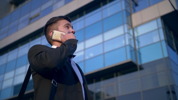 Young Handsome Businessman Talking on Mobile Phone in the City