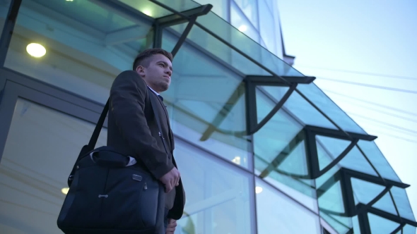 Young Stylish Businessman Walking Up the Stairs Towards Office Building